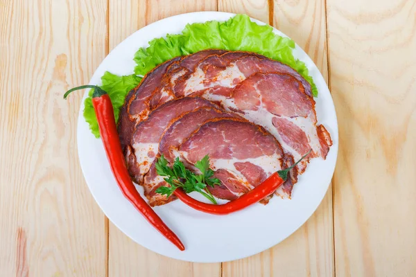 Sliced dried pork neck with greens and chili on dish — Stock Photo, Image