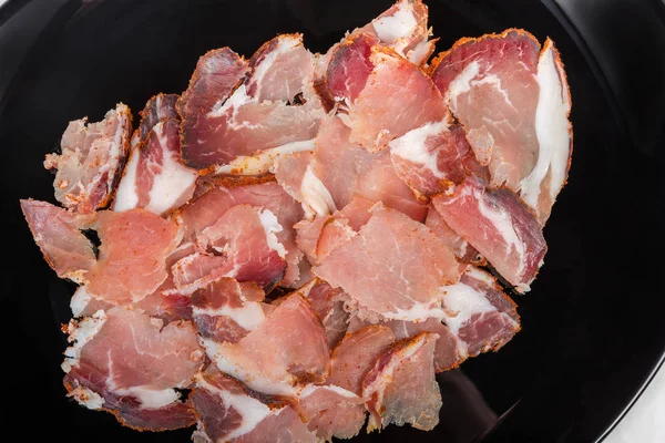 黒皿クローズアップに乾燥した豚の首の薄いスライス — ストック写真
