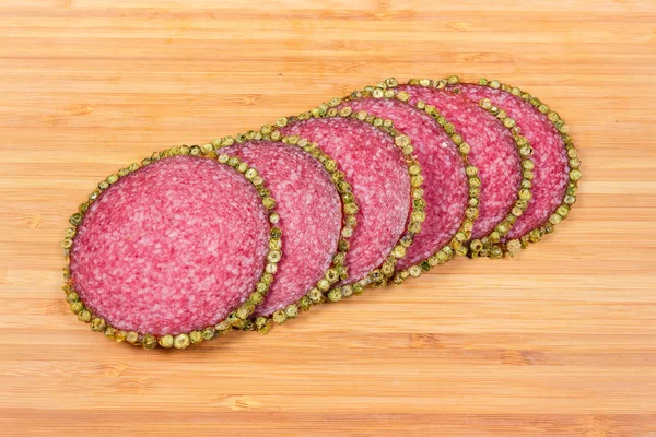 Fatias de pimenta salame revestido na placa de corte de madeira — Fotografia de Stock