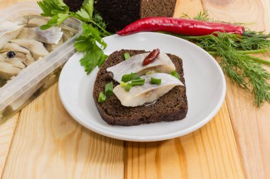 Onun hazırlanması için malzemeler arasında salamura ringa balığı ile açık sandviç