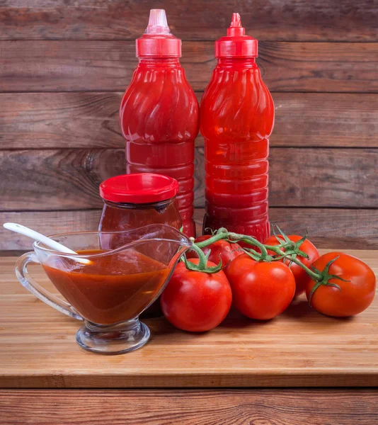 Różne sosy pomidorowe w różnych opakowaniach i świeżych pomidorów oddziału — Zdjęcie stockowe