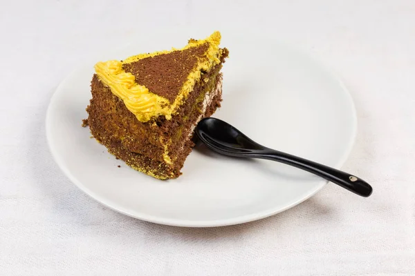 Rebanada de la torta de esponja de chocolate en capas en plato blanco — Foto de Stock