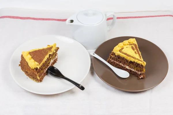 Slices of the layered chocolate sponge cake on two dishes — Stock Photo, Image