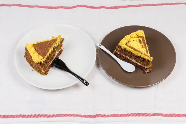 Rebanadas del pastel de esponja de chocolate en capas en dos platos — Foto de Stock