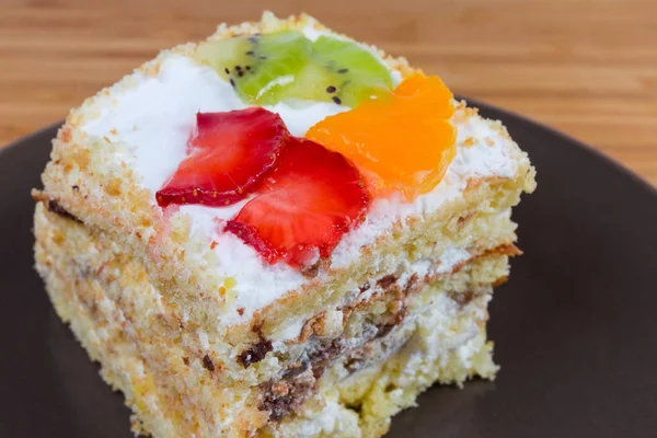 Rebanada de pastel de esponja en capas con frutas decoración primer plano — Foto de Stock