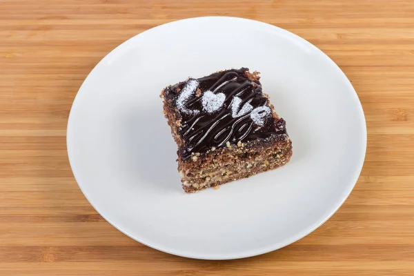 Fatia do bolo de esponja de chocolate em camadas no prato branco — Fotografia de Stock