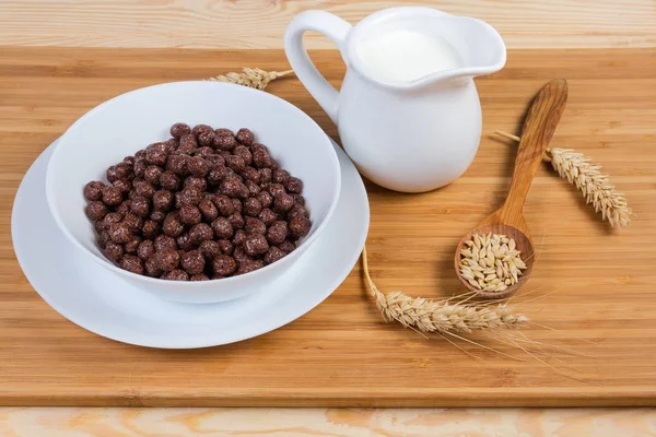 Boules de chocolat aux céréales pour petit déjeuner et lait entre les oreilles et les grains — Photo