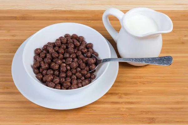 Boules de chocolat aux céréales dans un bol avec cuillère et lait — Photo