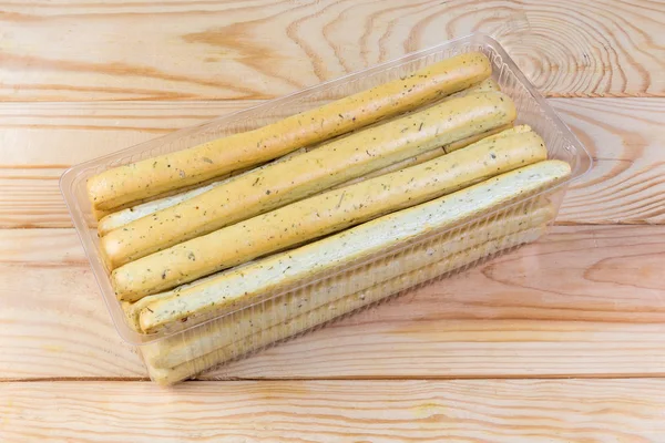 Breadsticks com ervas italianas em recipiente em uma mesa rústica — Fotografia de Stock