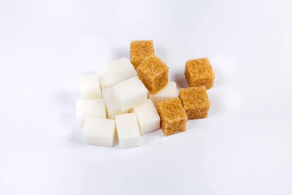Stos białych i brązowych kostek cukru na powierzchni świetlnych — Zdjęcie stockowe