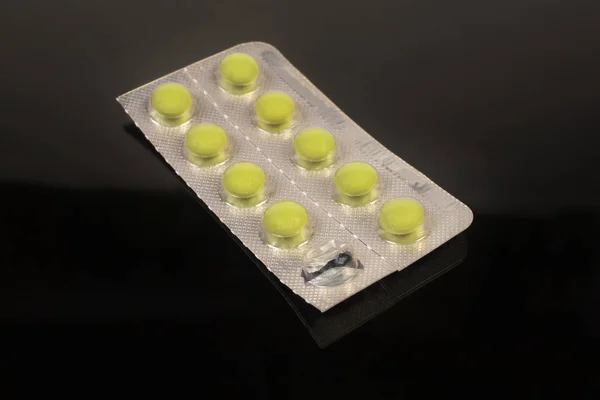 Blister Pack se žlutými pilulkami na tmavém pozadí — Stock fotografie