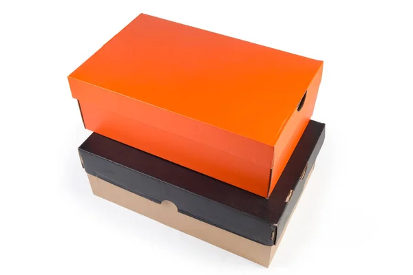 Закрытые черно-оранжевые коробки из-под обуви на белом фоне — стоковое фото