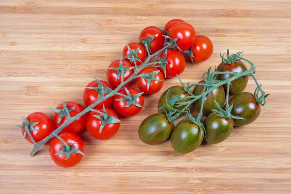 Clusters of red cherry tomatoes and cherry tomatoes kumato