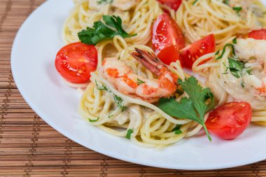 Karides kuyrukları ve kiraz domates yakın çekim ile Pişmiş Spagetti makarna