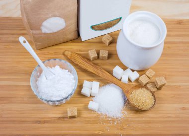 Ahşap yüzeyde farklı biçimlerde beyaz ve kahverengi şeker