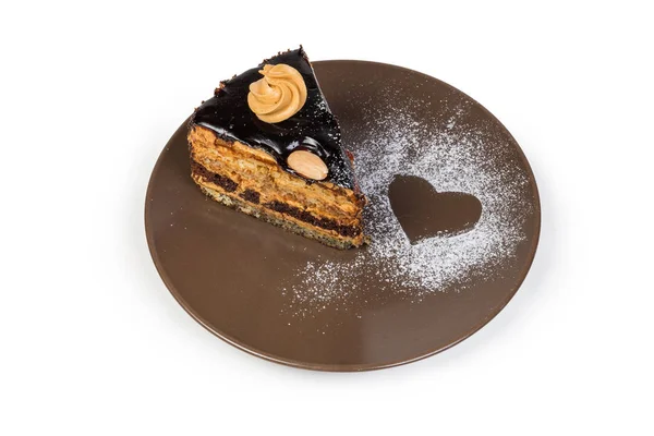 Kawałek warstwowej czekolady ciasto gąbką na brązowym naczyniu — Zdjęcie stockowe