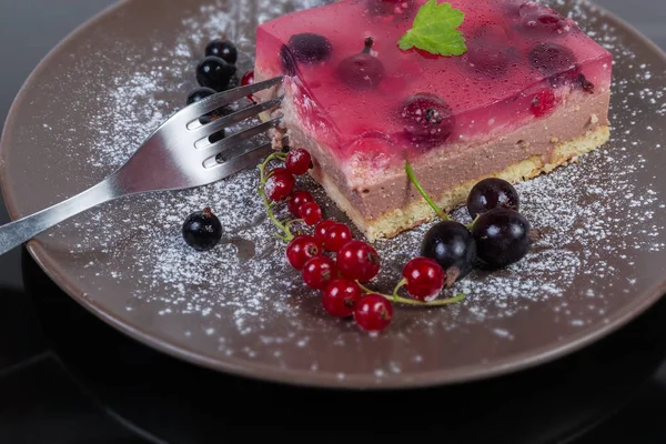 Pastel en capas con bayas frescas en el plato con tenedor primer plano —  Fotos de Stock