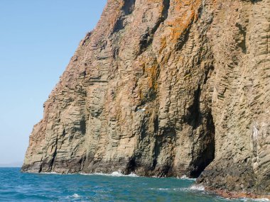 Deniz ve gökyüzü karşı volkanik kökeni kıyı kayalıkları