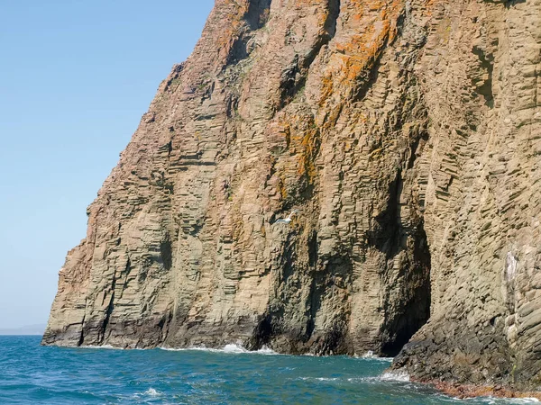 Deniz ve gökyüzü karşı volkanik kökeni kıyı kayalıkları