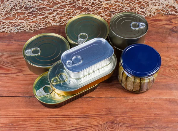 Peixe enlatado em diferentes latas seladas e frasco de vidro — Fotografia de Stock