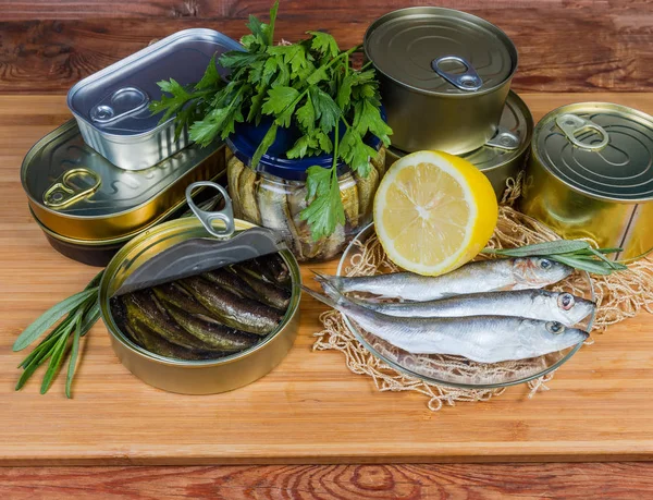 Sprats in open tin can among canned fish, raw fish — Stock Image Sprats in open tin can among canned fish, raw fish Stock Image