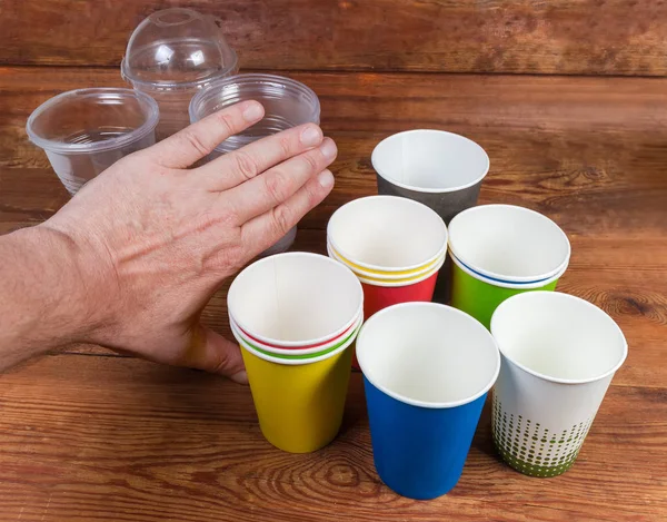 Tazas de papel desechables y mano empujando hacia atrás vajilla desechable de plástico —  Fotos de Stock