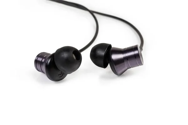 Auriculares negros en la oreja primer plano sobre un fondo blanco — Foto de Stock
