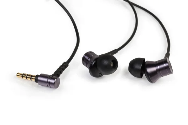 Auriculares negros con cable en la oreja primer plano sobre fondo blanco —  Fotos de Stock