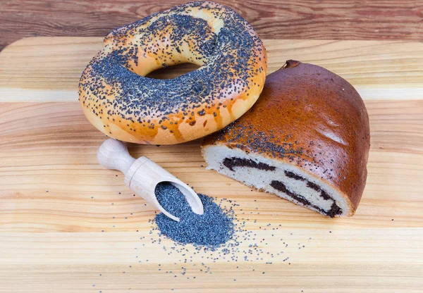 Poppy seeds in spice spoon, bagel and poppy seed roll