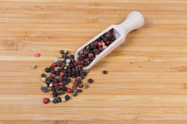 Tahta baharat kaşığı ve yanında farklı biber karışımı