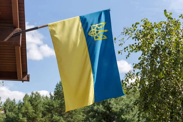 Bandera nacional ucraniana en una fachada del edificio contra del cielo — Foto de Stock