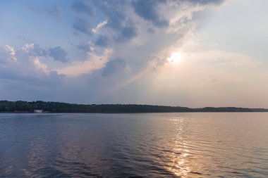 Gökyüzü bulutlar ve güneş rezervuar ve kıyı üzerinde