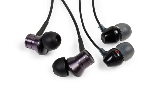 Diferentes auriculares negros en la oreja primer plano sobre fondo blanco —  Fotos de Stock