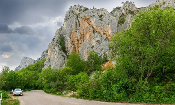 Vieja carretera serpenteante en el bosque cerca de los acantilados — Foto de Stock