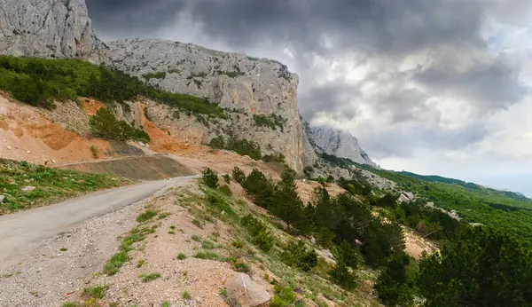 Viejo camino de montaña cerca de los acantilados, deslizamiento de tierra desde la pendiente — Foto de Stock