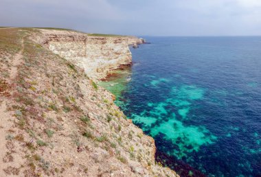 Dik dokulu kireçtaşı kayalar ve uzak ufuk ile deniz kıyısı
