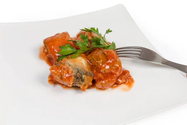 Консервированная рыба в томатном соусе на блюде крупным планом — стоковое фото