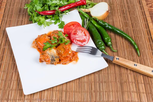 Peixe enlatado em molho de tomate em prato, verduras e verduras — Fotografia de Stock