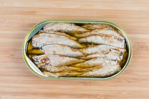 Open tin cans with sprats on wooden surface, top view — Stock Image Open tin cans with sprats on wooden surface, top view Stock Photo