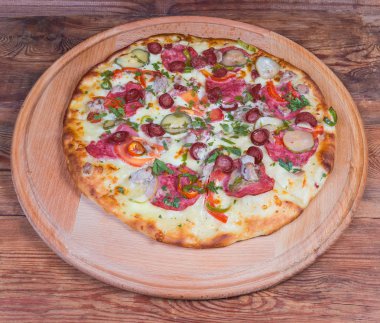 Pizza servis tahtasında farklı sosisile pişmiş pizza