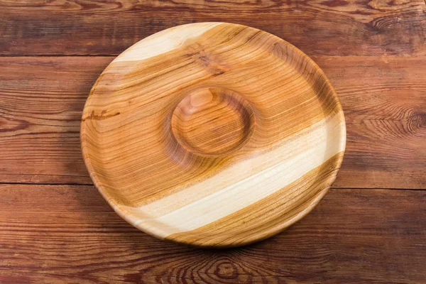 Round wooden serving dish with sauce boat on rustic table — Stock Photo, Image