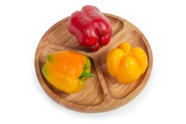 Ahşap tabakta kırmızı ve sarı dolma biber.