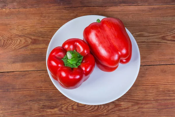 Vista dall'alto di due peperoni rossi freschi sul piatto — Foto Stock