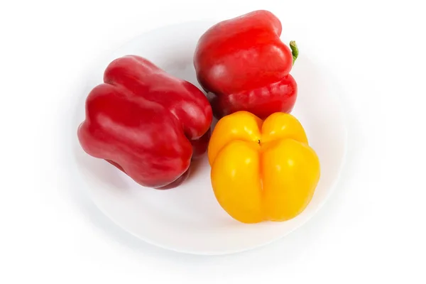 Rode en gele paprika 's op de witte schaal — Stockfoto