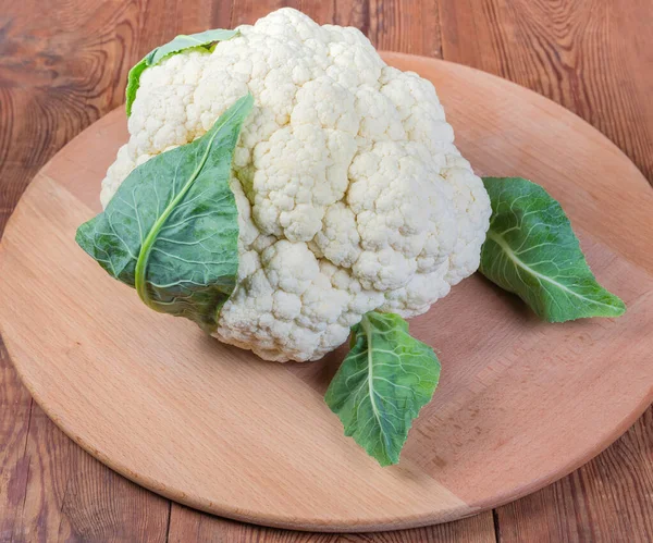 Fresh cauliflower head on the wooden serving board — Stock Photo, Image