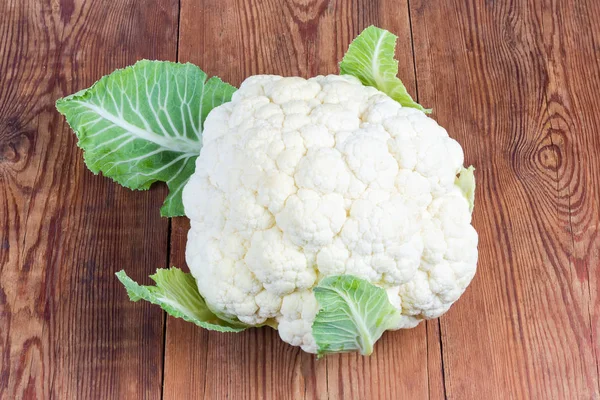 Whole raw cauliflower head on the old rustic table — Stock Photo, Image