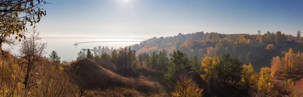 Крутий берег водойми з деревами в ранковому тумані, панорамний — стокове фото