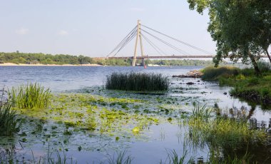 Modern yol kablolu köprüsünün üzerinde yarım yelpaze dizaynından oluşan bir pilon ve çelik kablo var. Pivnichnyi (eski Moskovskyi) Dnieper Nehri üzerindeki köprü, Kyiv, Ukrayna