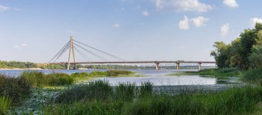 Modern yol kablolu köprüsü nehrin üzerinde diğer demiryolu köprüsüne karşı. Pivnichnyi (eski Moskovskyi) Dnieper Nehri üzerindeki köprü, Kyiv, Ukrayna