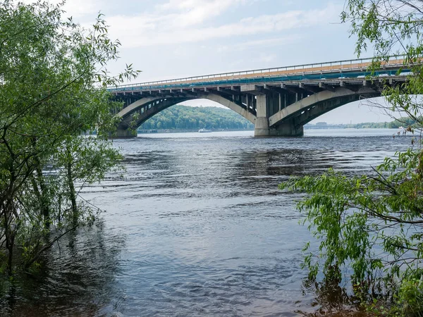 地铁汽车拱桥横跨河上 望着春天柳树间的部分桥梁 跨越乌克兰基辅第聂伯河的地铁大桥 — 图库照片